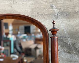This lot features an antique American Empire gentleman’s shaving mirror with a tilt-top frame, fluted upright supports, and a shaped base with bun feet. This mirror measures, 33” H x 30” W x 12” D.
