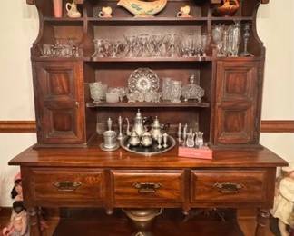Tavern style two piece hutch. Vintage pottery. Glassware and silverplate serving pieces