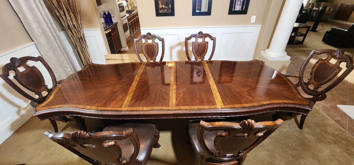 Timeless Luxury! This formal dinning set has two removable leafs, six chairs (2w/arms), and a matching wood & glass display buffet that stores the leafs when not in use. Amazing condition and for sale at 93% off the retail price!!!