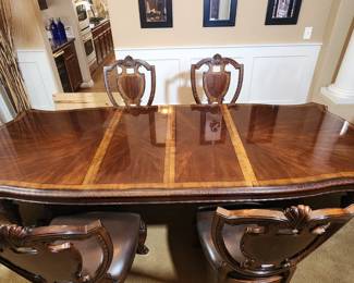Timeless Luxury! This formal dinning set has two removable leafs, six chairs (2w/arms), and a matching wood & glass display buffet that stores the leafs when not in use. Amazing condition and for sale at 93% off the retail price!!!