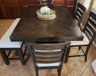 Bar height nearly new dining set. Set includes bench and four matching chairs. Table had storage underneath as well!