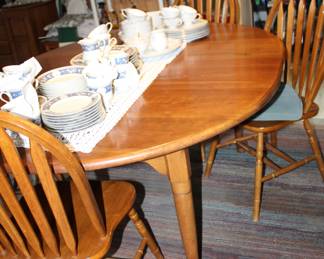 solid-wood dining table with four Windsor chairs and two leaves