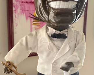 Vntage, animated Louis Armstrong singing doll produced by Gemmy Industries in the early 2000s.
The figure is part of the Gemmy Pop Culture Series and stands approximately 19 inches (48 cm) tall. When activated, the doll moves its head, arm, and mouth, and its eyes widen as it sings songs like "What a Wonderful World" and "Hello, Dolly!
