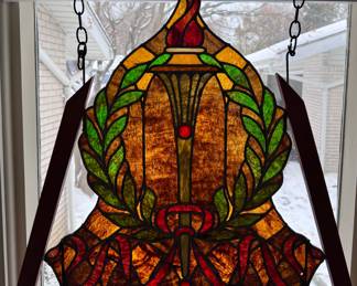 Reclaimed antique stained glass window panel featuring symbolic motifs. 
The central design includes a flaming torch encircled by a laurel wreath and ribbon.
The torch and laurel symbolize enlightenment, achievement, and civic pride.
The piece is likely American, dating from the 1910s-1920s, and made of leaded, mottled opalescent glass.
Piece has been custom framed for stability.

$300 OBO