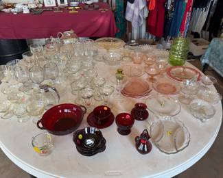 Depression glass, red glass items, sundae glasses, beer goblets, dessert dishes, syrup dispenser.