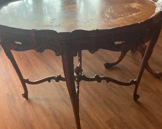 Antique, French-style, carved walnut coffee table featuring satinwood inlay and a floral motif. 