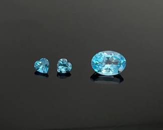 These bright blue topaz gemstones are ready to be custom jewelry for that special person with a December birthday. (1) 7.10 ct 13.9 mm x 10.1 mm oval cut stone and (2) 1 ct ea 6 mm heart cut stones. 