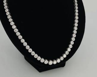 Platinum 17" necklace, stamped "Oscar Friedman", set with (79) round brilliant cut, bezel set diamonds. 19.41 ctw. Finished with a tension lock clasp and folding safety clasp. 47.2 gtw. Matches bracelet in Lot 8. Includes appraisal dated April 3, 2024 by American International Gemological Laboratories, Inc. Appraisal provided by consigner.