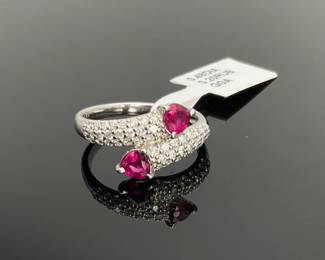 Platinum size 7.75 ruby and diamond ring. Two (2) GGS identified heart cut rubies, weighing 0.2 ctw, are mounted in the center of the ring. (48) round cut diamonds, weighing approximately 0.48 ctw, accent around and on either side of the center stones. 5.8 gtw. Includes appraisal dated June 26, 2023 by GemAssure Gemological Appraisals. Appraisal provided by consigner. 