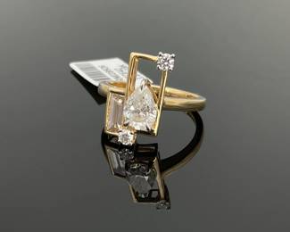 18K yellow gold size 7 ring, stamped Oscar Friedman set with (4) diamonds. (1) 1.02 ct pear cut diamond, (1) 0.33 ct rectangular cut diamond and (2) round cut 0.14 ctw diamonds. 3.8 gtw. Includes appraisal dated November 3, 2025 by American International Gemological Laboratories, Inc.