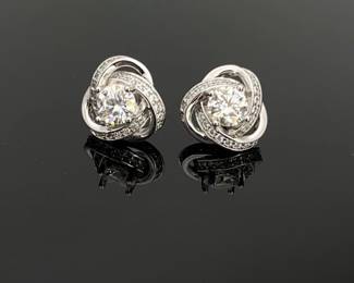 A 6.5 mm 1 ct clear moissanite sits at the center of each earring. Set in unmarked silver tone, smaller moissanites surround the center stone in a Celtic knot style pattern. 5.1 gtw. Includes GRA certificate of authenticity.