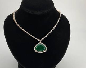 A 15 ct modified heart cut GIA certified emerald hangs in the center of the 16" necklace with (223) round cut diamonds surrounding the emerald and lining the chain of this two-tone platinum necklace. 36.4 gtw. Includes appraisal dated October 14, 2025 by GemAssure Gemological Appraisals. Appraisal provided by consigner.