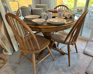 Round dining table with glass top and set of four chairs