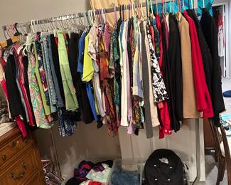 One of  four clothing racks with blouses and jackets a few large jeans and slips and nightgowns, very silky
