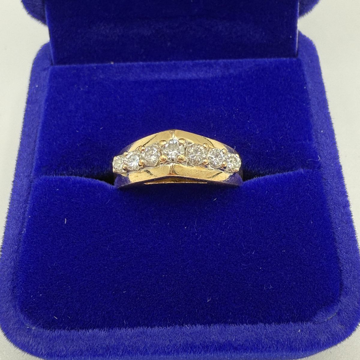This is a stunning 14 karat gold and diamond ring with a lovely bridge setting that includes a total of seven diamonds. With .139 Troy ounces of gold and seven diamonds with lovely fluorescence, this is both a great gift and an investment piece. Diamonds show lovely fluorescence. Gift box is included for your storage or gift giving.