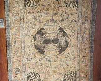 Antique Chinese Ningxia Buddhist Altar Rug — Signed
A finely hand-knotted Chinese Ningxia altar rug, dating to the late 19th–early 20th century, featuring a central flaming jewel / censer motif surrounded by auspicious cloud and lotus designs. Traditional wave and mountain patterns form the lower border, symbolizing harmony between heaven and earth. The soft, muted palette of golds, greys, and blues is characteristic of classic Ningxia weaving. The rug includes a signed calligraphic inscription cartouche at the top, indicating temple or donor attribution. Wool pile on a woven foundation with original fringe.
A beautiful and symbolic example of Buddhist devotional textiles — ideal for display or collection.
