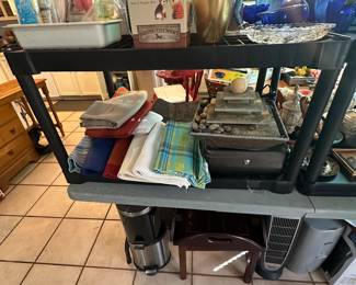 Scale, S/P set in box, blue glass vases & miscellaneous other items on top shelf, place mats & tablecloths, water fountain, miscellaneous other items on floor 