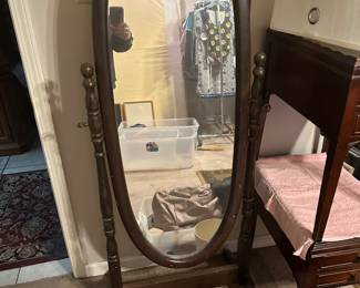 Large mirror on frame that tilts, small table to left 