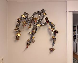 Decorative metal wall art. Hand formed petals and leaves of brass, copper, and steel tones, welded and wired forming this wall mounted botanical form