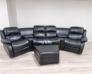 Black leather sectional media lounge sofa with 4 reclining seats, beverage holders, and storage arms. Matching storage ottoman also