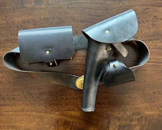 Leather gun belt, belt buckle, holster and pouch.