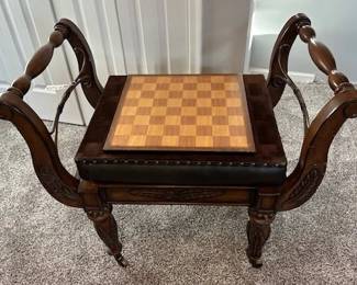 Decorative wooden chess table with built-in board and upholstered seat.