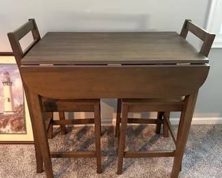 3-Piece wooden counter height drop leaf dining table with two chairs.