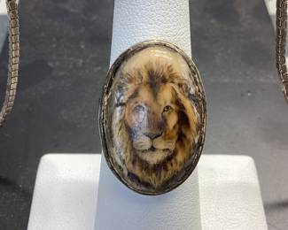 ANTIQUE SILVER JEWELRY LOT EARLY 20TH CENTURY COMMEDIA DELL'ARTE RENAISSANCE REVIVAL PENDANT (POSSIBLE PERUZZI OR COPPINI DESIGNED) SET IN 800(80%) SILVER FEATURING A CABOCHON CHRYSOPRASE. THE ANTIQUE PIECE IS HUNG FROM A 24 INCH STERLING BOX LINK CHAIN. WEIGHT 26.56 GRAMS. ALSO AN ANTIQUE STERLING SCRIMSHAW RING WITH LIONS HEAD ETCHING. WEIGHT IS 9.42 GRAMS, SIZE 6.5. RING HAS SIGNS OF AGE AROUND THE OUTER DIAMETER. PATINA HAS BEEN KEPT TO PRESERVE THESE PIECES