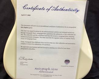 ERIC CLAPTON AUTOGRAPHED FENDER 6 STRING ELECTRIC GUITAR WITH CERTIFICATE OF AUTHENTICITY FROM AUTOGRAPH STORE NY, NY. ORIGINALLY FEATURED IN A BENEFIT AUCTION AT CHAPEL HILL 2014. INCLUDES FRAMED TIME PIECES VINYL ALBUM, BEST OF EC CD AND FRAMED PHOTO