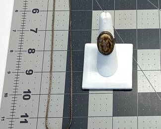 ANTIQUE SILVER JEWELRY LOT EARLY 20TH CENTURY COMMEDIA DELL'ARTE RENAISSANCE REVIVAL PENDANT (POSSIBLE PERUZZI OR COPPINI DESIGNED) SET IN 800(80%) SILVER FEATURING A CABOCHON CHRYSOPRASE. THE ANTIQUE PIECE IS HUNG FROM A 24 INCH STERLING BOX LINK CHAIN. WEIGHT 26.56 GRAMS. ALSO AN ANTIQUE STERLING SCRIMSHAW RING WITH LIONS HEAD ETCHING. WEIGHT IS 9.42 GRAMS, SIZE 6.5. RING HAS SIGNS OF AGE AROUND THE OUTER DIAMETER. PATINA HAS BEEN KEPT TO PRESERVE THESE PIECES