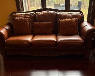Ashley brand 2 Leather sofas with wood detail. Bottom cushion is Velcro so it doesn’t move. In excellent condition comes with 6 decorative pillows 