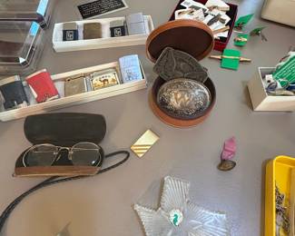 Waterford Crystal Texas paper weight, Antique American Optics eyeglasses, Belt Buckles, Camel lighter, Zippo brass and Chrome Lighters