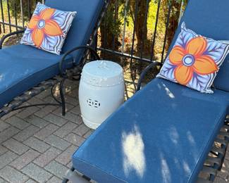 Pair of outdoor lounge chairs with cushions and drum table