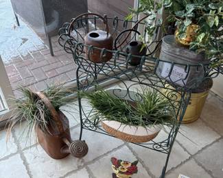 iron planter, watering can and faux plants