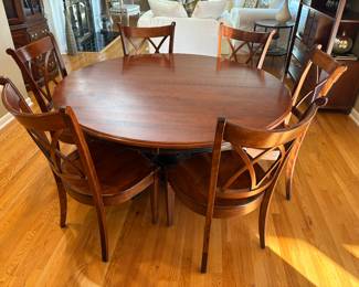 60" round wood center pedestal table (pedestal base is black) with 6 wood side chairs.  Table has 1 additional leaf. 