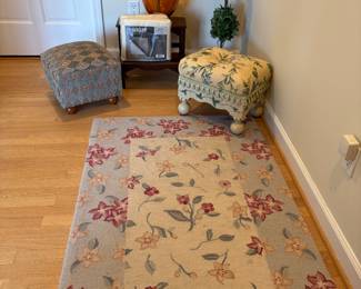 Wool area rug, ottomans and wood stair-step, topiary, and glass vase