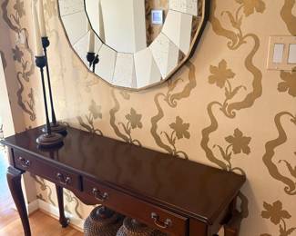 Console table with two drawers, candleholders, and large mirror, and also rattan canisters