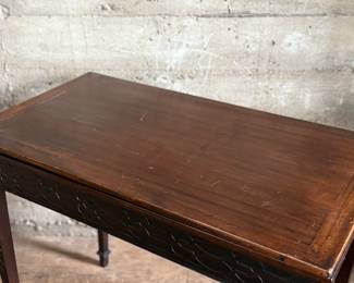 This lot features an antique George III solid mahogany game table. This table is in good overall condition, but does have one loose leg shown in photos. This table measures closed, 29” H x 19” W x 36” D and open, 29” H x 38” W x 36” D.
