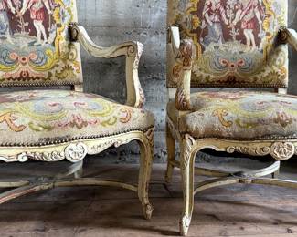 This lot features a pair of 19th century French Louis XV style armchairs with original tapestry upholstery and a painted, carved wood frame. Each chair measures, 41” H x 25” W x 21.5” D.
