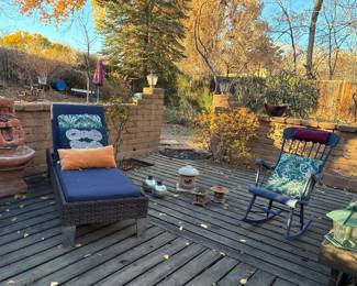 Stone fountain, wicker chaise lounge with cushions, rocking chair, Japanese platform lantern