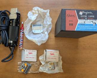 A number of  vintage, unused Oster clippers with accessories in original box