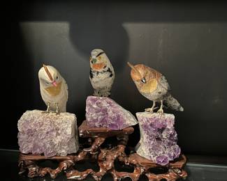 Gem stone birds figurines on amethyst rocks 