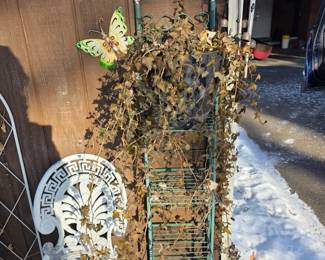 white cast iron chair and a small green metal plant stand or trellis, l