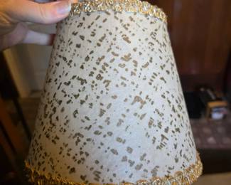 small, tapered or empire-shaped lamp shade with a gold-speckled or animal print pattern and gold trim. 