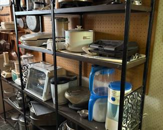 black metal shelving, small kitchen appliances, stainless bowls, pots and pans, bbq tools