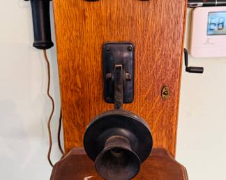 antique Western Electric oak wood hand-crank wall-mount telephone.