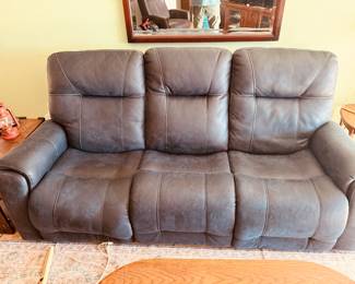 Signature Design by Ashley power reclining sofa, likely from a collection such as the Barnsana, Point Clear, or Technique series, featuring a faux leather polyester upholstery in a dark gray or blue-gray color.