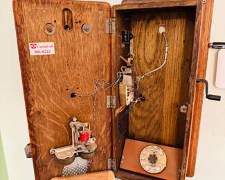 antique Western Electric oak wood hand-crank wall-mount telephone.