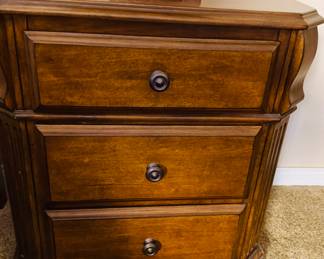 This is a Signature Design by Ashley Wyatt 3-drawer nightstand in a medium brown cherry finish.