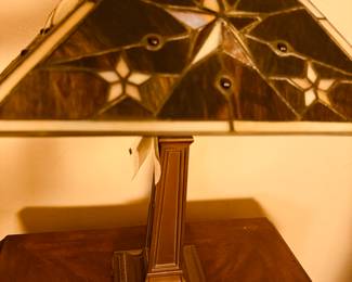 This is a Tiffany-style stained glass table lamp with a mission design base.
